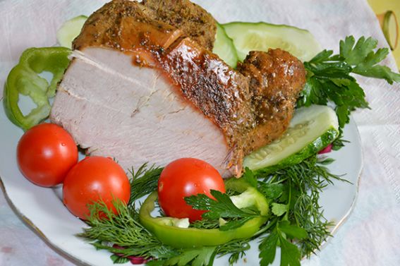 A plate of food with meat, vegetables and tomatoes.