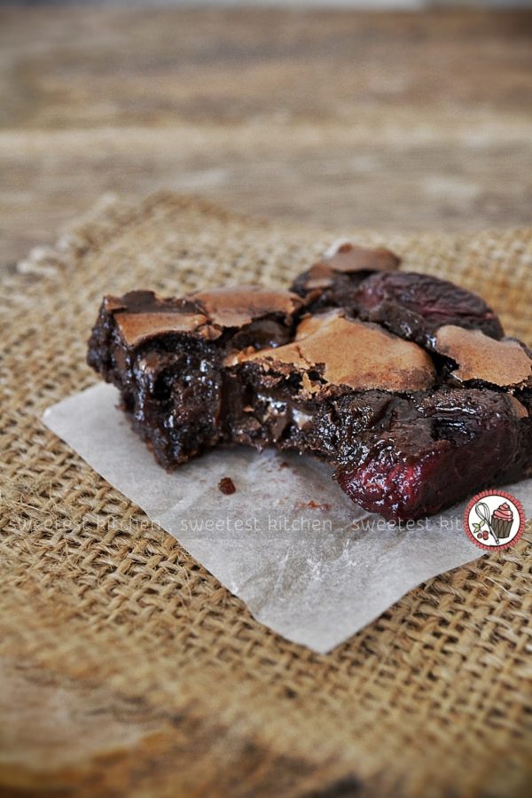 A piece of brownie sitting on top of a paper.