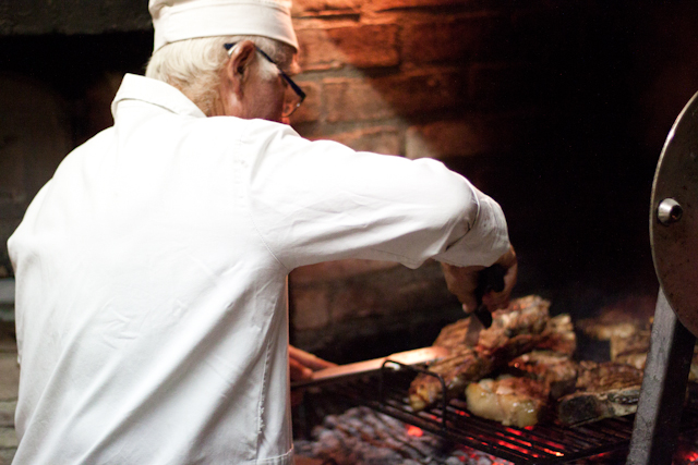 A chef cooking food on an outdoor grill.