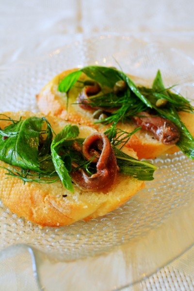 A close up of two pieces of bread with meat and greens