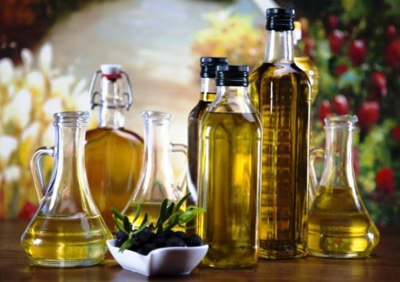 A table topped with lots of bottles and bowls filled with olive oil.