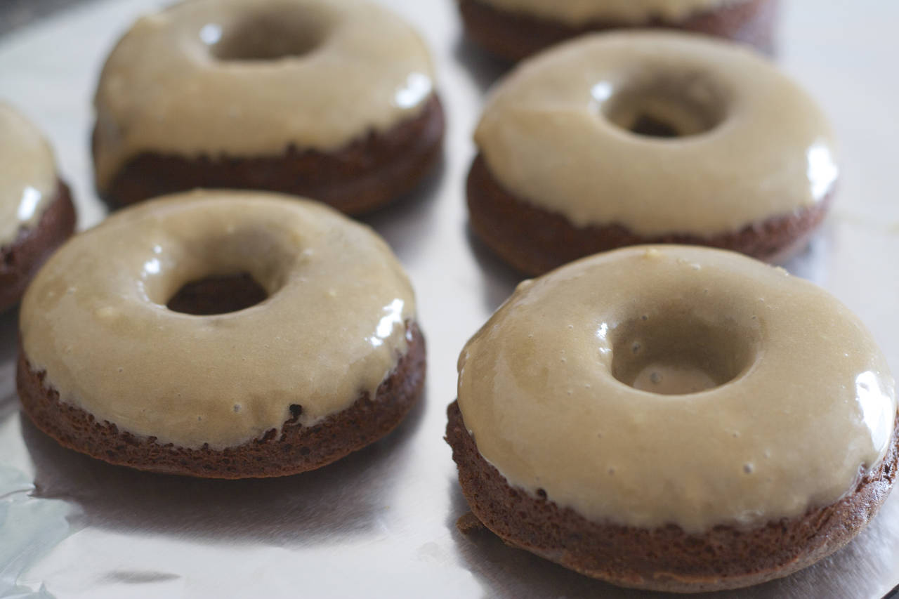 A close up of several doughnuts with frosting.