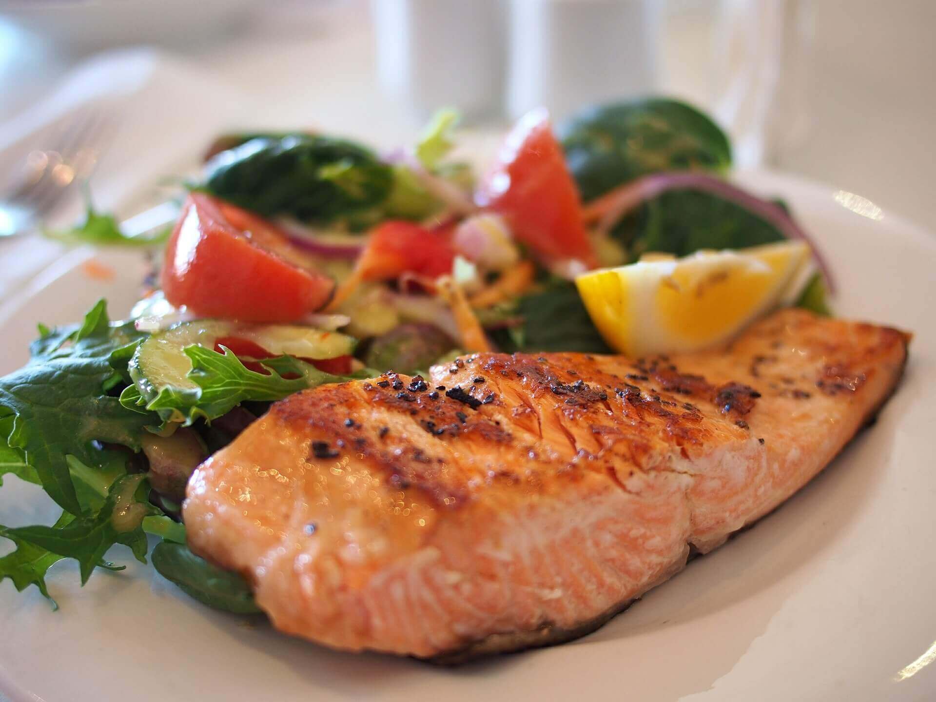 A plate of food with salmon and vegetables.