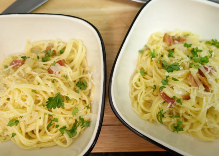 Two bowls of pasta with meat and vegetables.